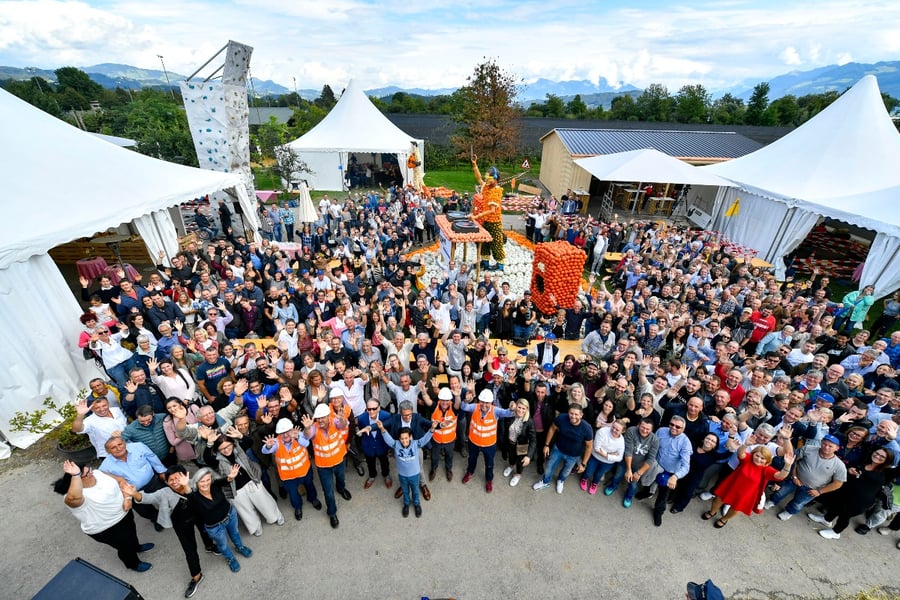 Die Mitarbeiter*innen mit Ihren Partner*nnen der Schmid Gruppe stehen zusammen und feiern.