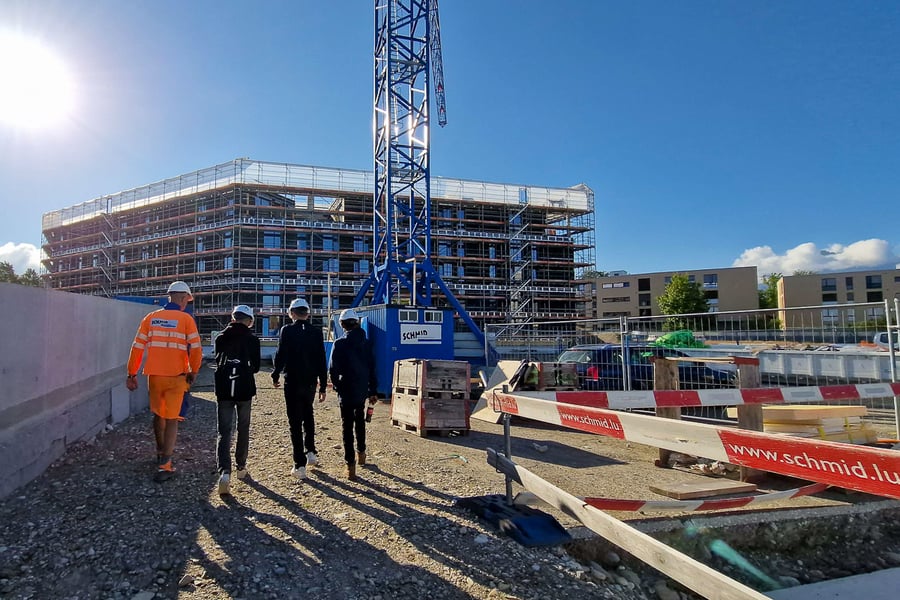 Bauarbeiter mit Schüler auf Baustelle am Lehrstellenparcours