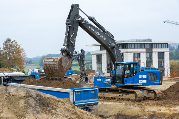 Bagger welcher Aushubmaterial auf einen LKW läd.