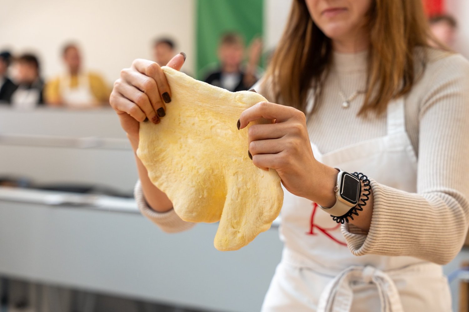 Pizzateig wird auseinandergezogen.