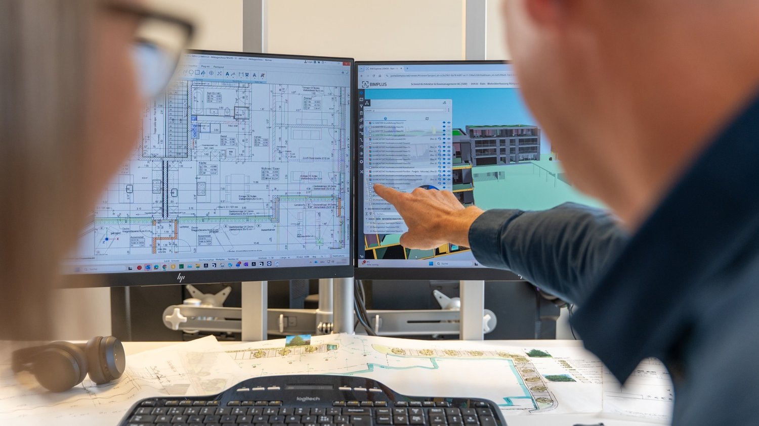 Zwei Mitarbeiter die einen Plan besprechen am CAD