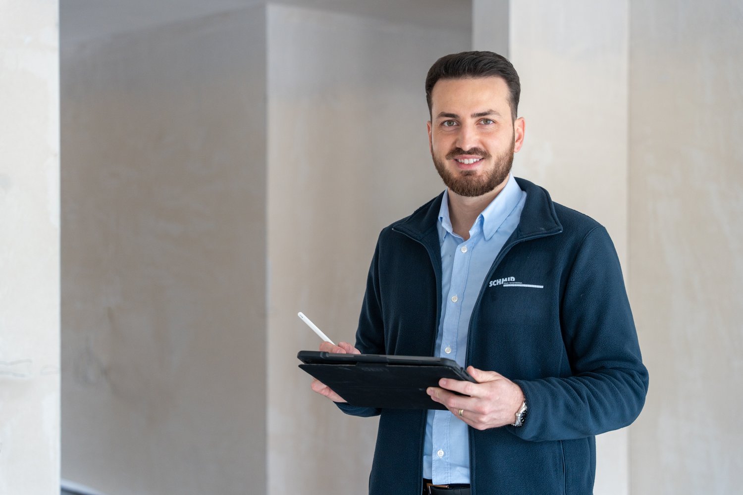 Mitarbeiter mit einem Tablet im Rohbau
