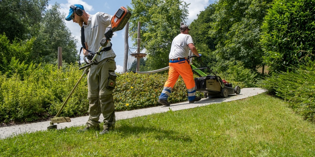 Zwei Schmid Mitarbeiter bei der Rasenpflege
