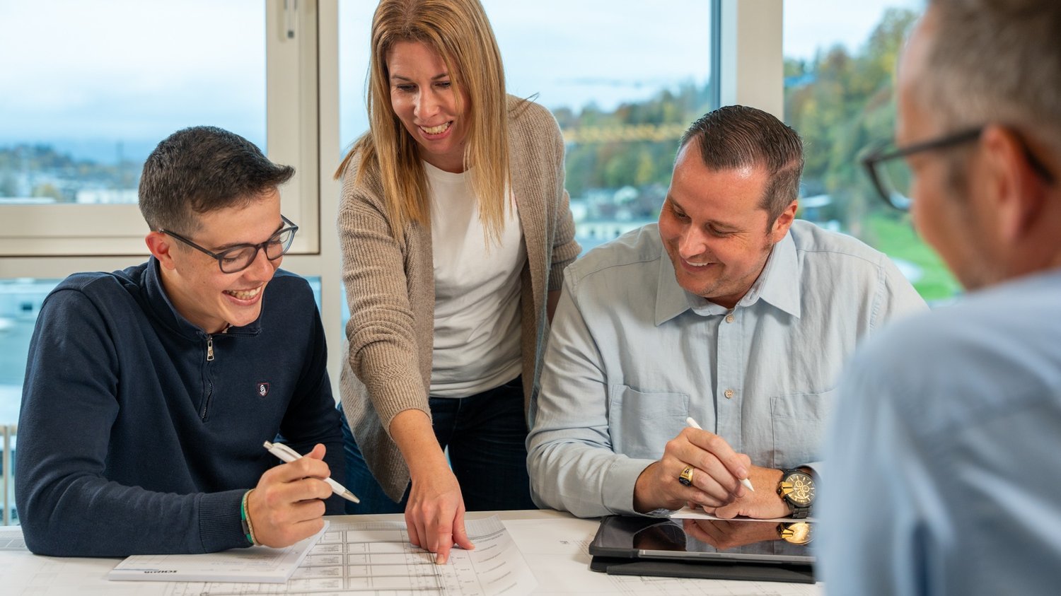 vier Personen im Gespräch an einer Sitzung
