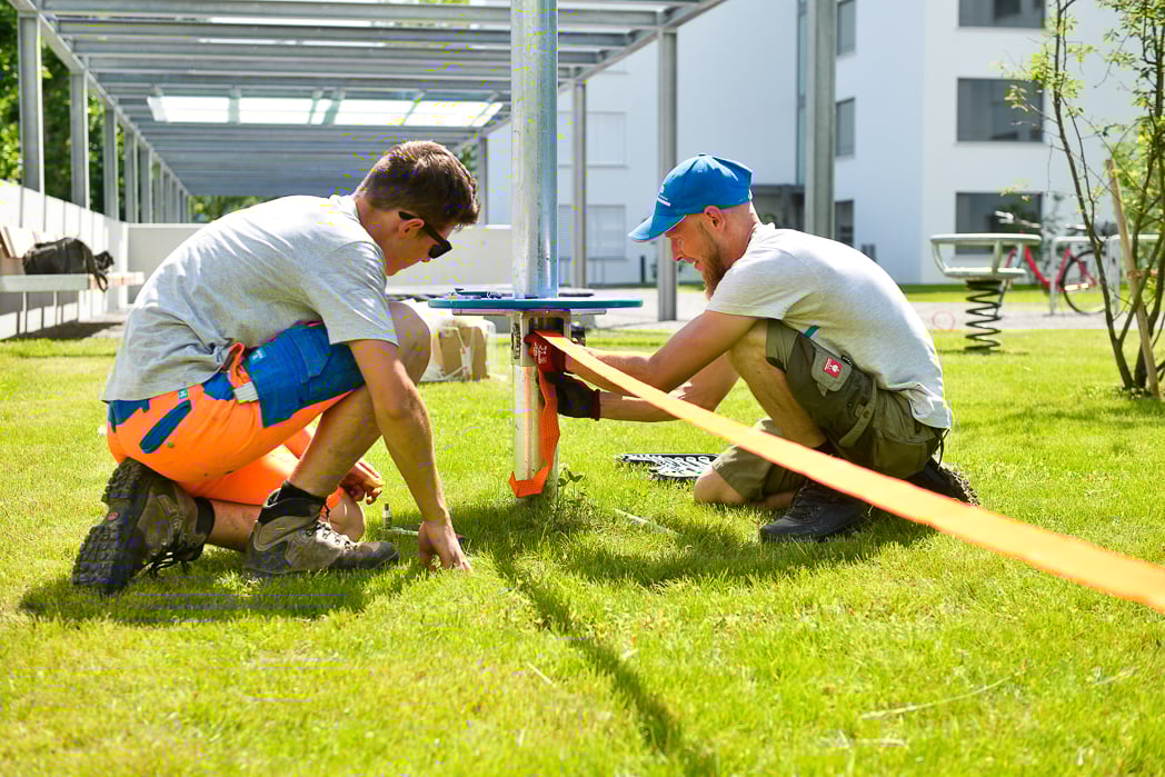 Schmidmitarbeiter bei der Montage eines Spielgerätes auf dem Spielplatz