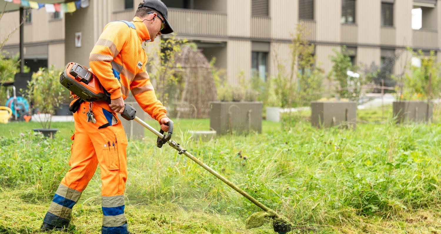 Gartenbaumitarbeiter beim Rasenmähen
