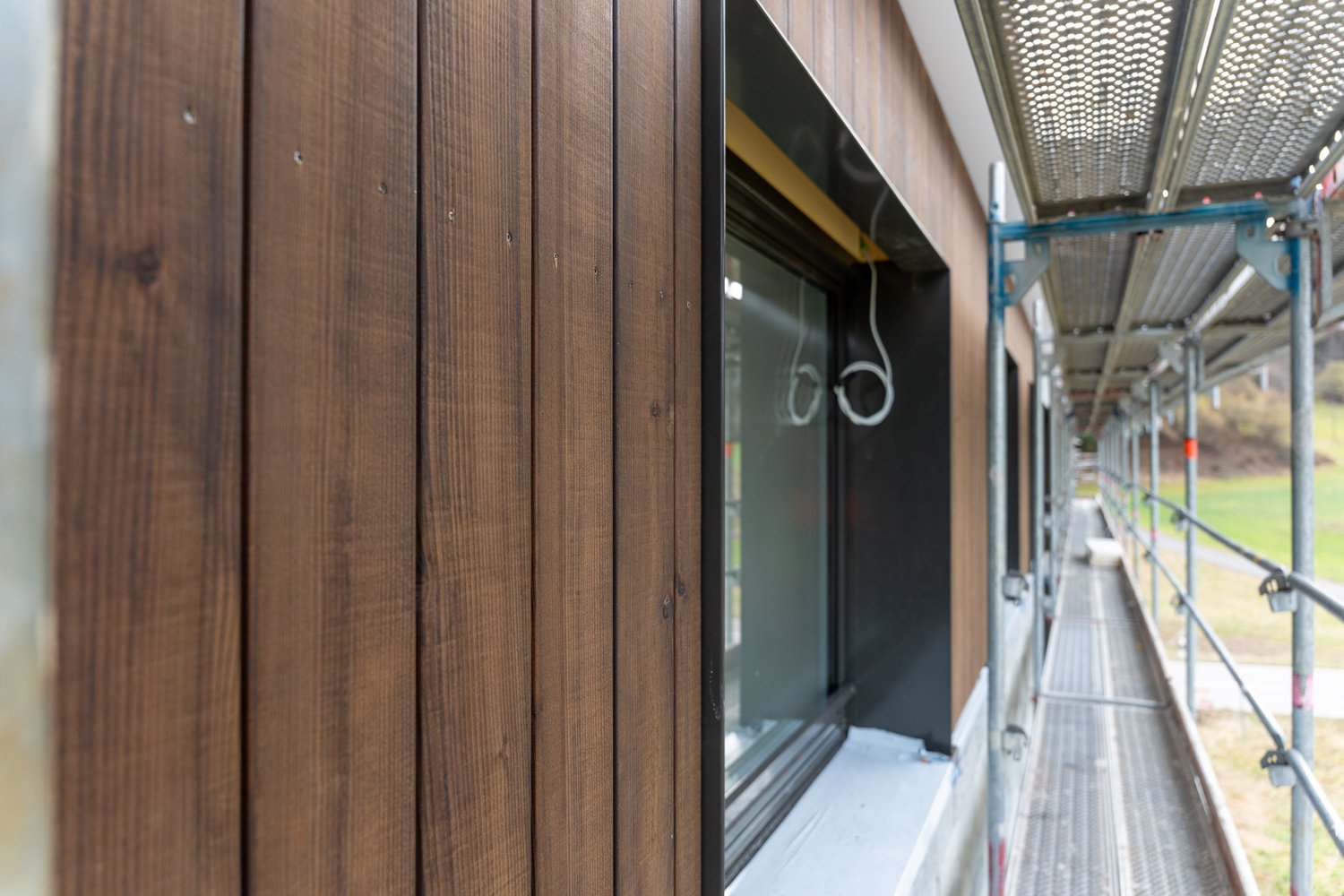 Holzfassade mit Abschluss zum Fenstersturz