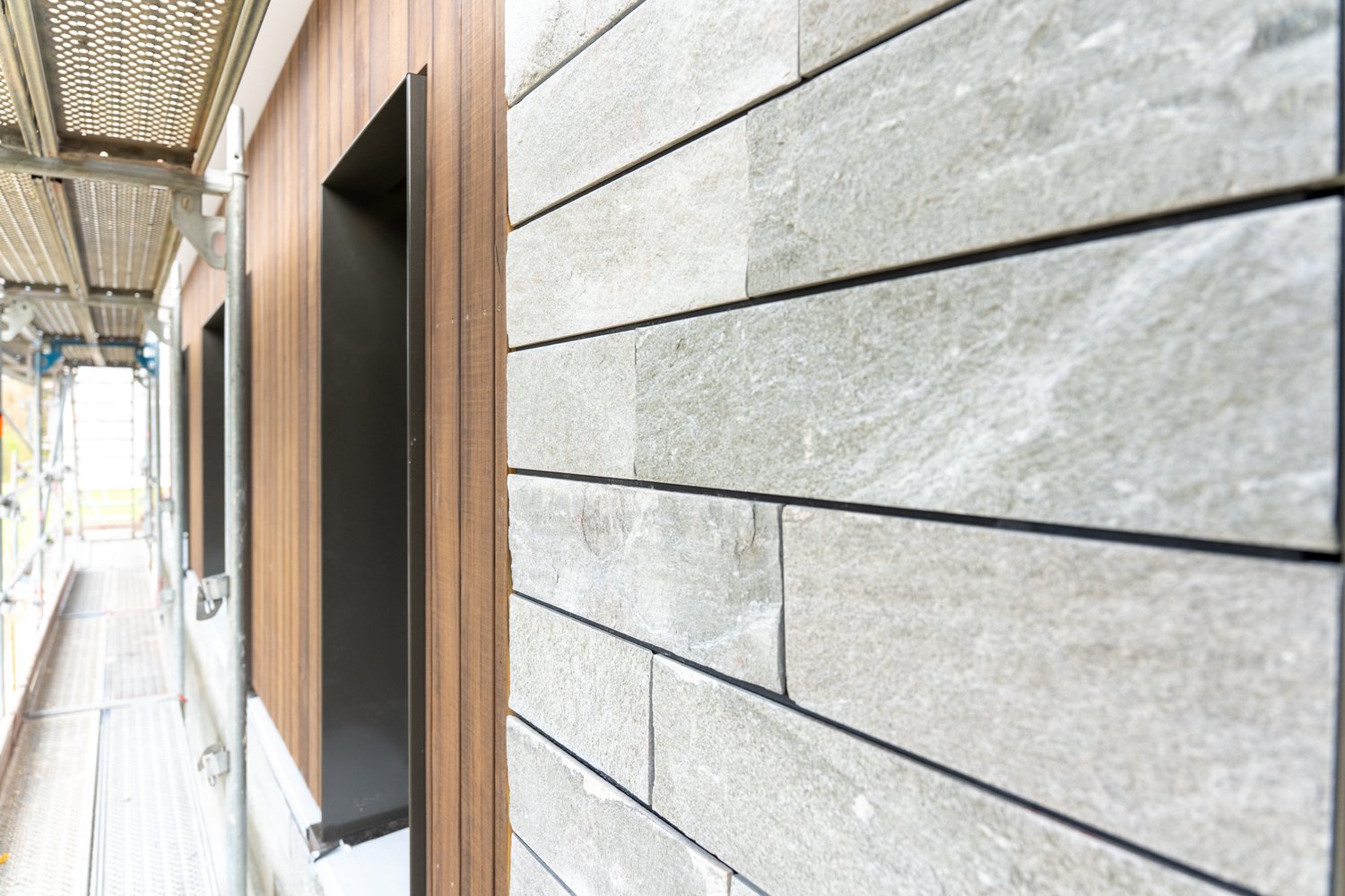 Holzfassade und Steinfassade