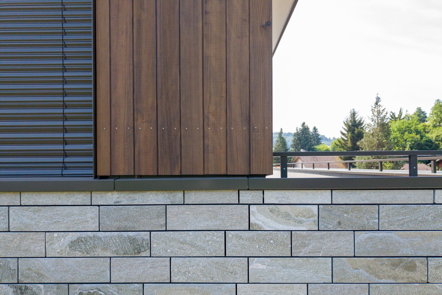Detail Holzfassade und Steinfassade