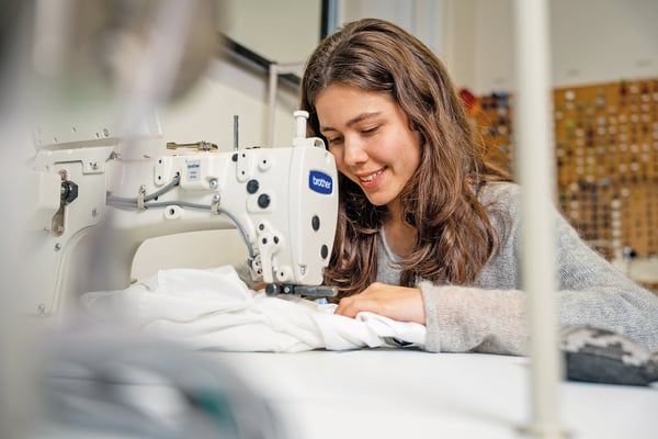 Eine junge Frau an der Nähmaschine