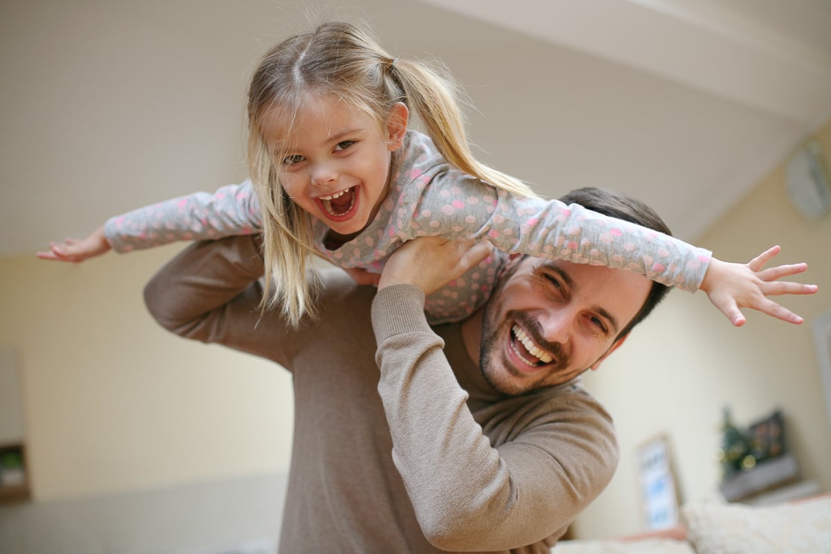 ein Vater der mit seiner Tochter fliegen spielt