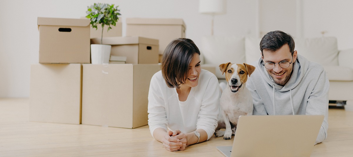 Junges Paar mit Hund bezieht Wohnung.