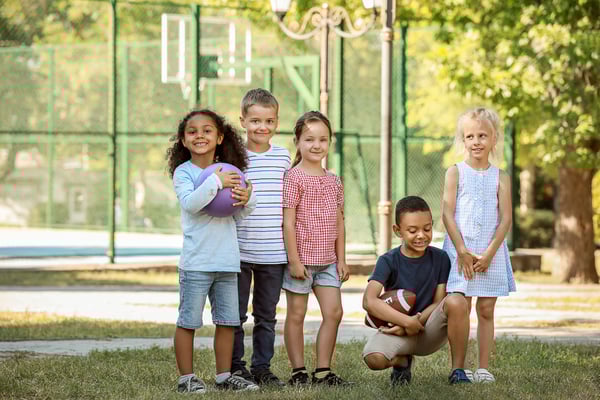 Kinder die in einer Gruppe stehen und draussen spielen wollen